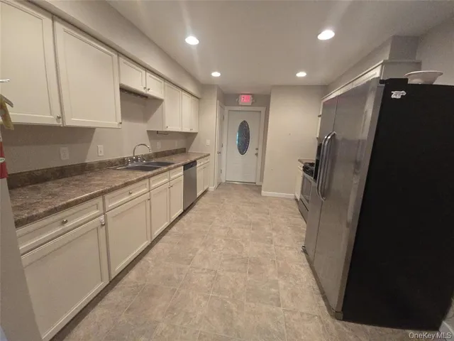 a kitchen with stainless steel appliances granite countertop a refrigerator and a stove