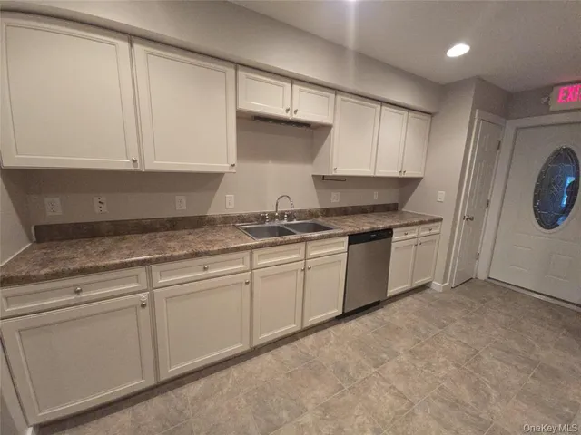 a kitchen with granite countertop white cabinets and a sink