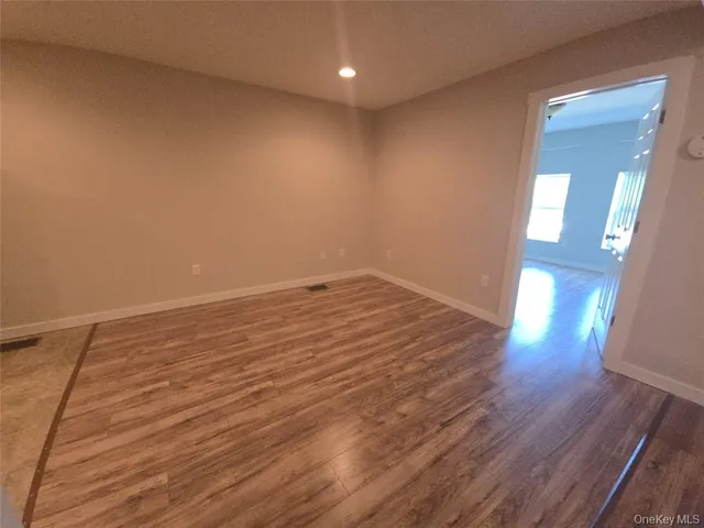 an empty room with wooden floor and entrance
