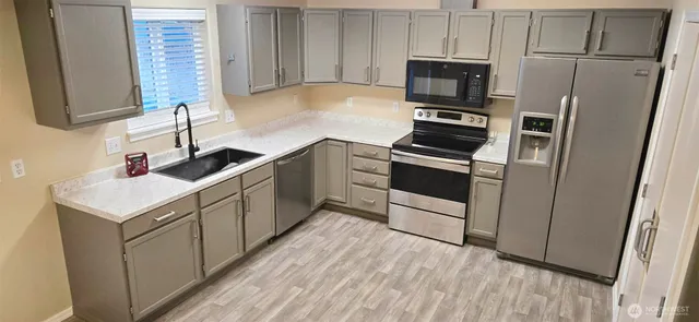a kitchen with white cabinets and stainless steel appliances