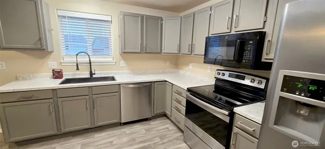 a kitchen with sink a microwave and cabinets