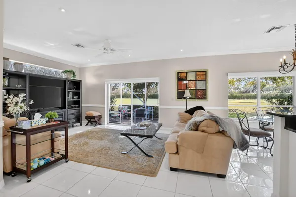 a living room with furniture a flat screen tv and a large window