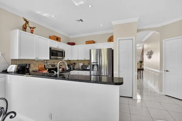a kitchen with stainless steel appliances granite countertop a refrigerator and a sink