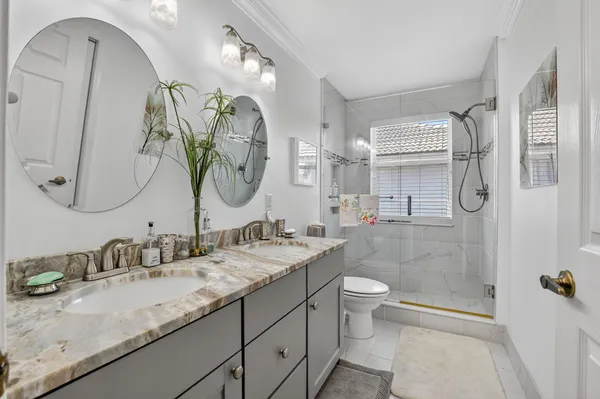 a bathroom with a granite countertop sink mirror and toilet