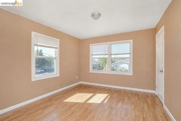 a view of an empty room with wooden floor