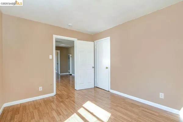 an empty room with a window and wooden floor