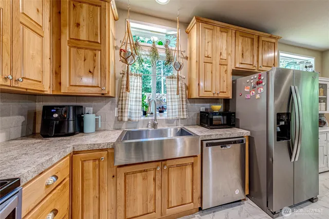 a kitchen with stainless steel appliances granite countertop a refrigerator and a sink