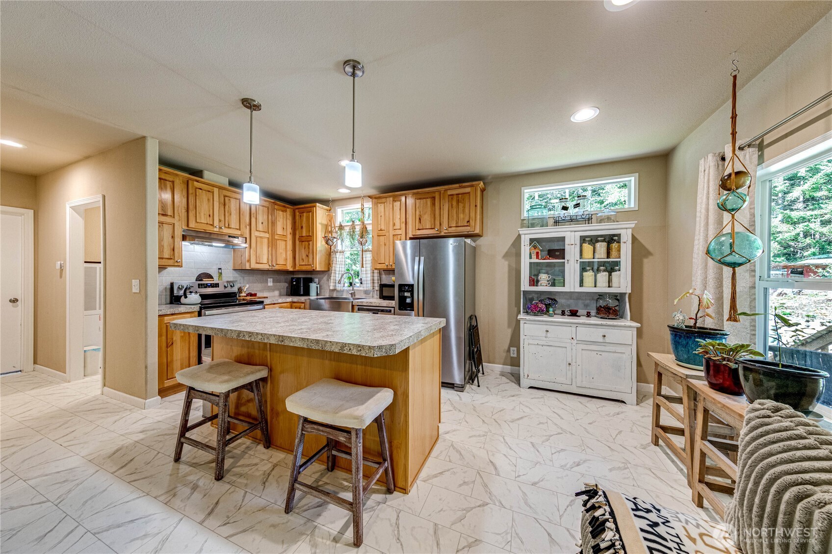 51 Sunflower Road Port Angeles, WA 98363 - Photo 12 of 40 a large kitchen with kitchen island a large counter top space a sink stainless steel appliances and cabinets