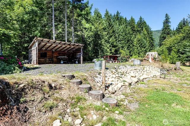 a backyard of a house with table and chairs and wooden fence