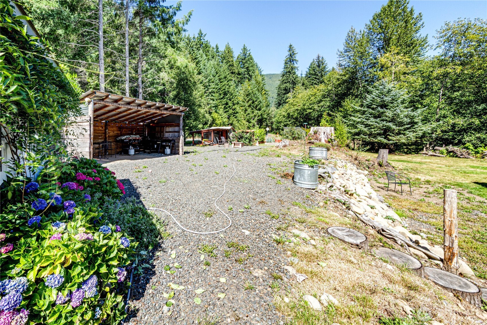 51 Sunflower Road Port Angeles, WA 98363 - Photo 24 of 40 a backyard of a house with table and chairs and wooden fence