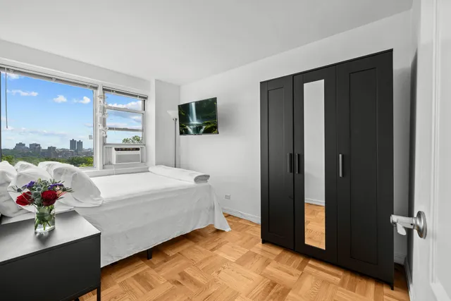 a spacious bedroom with a bed and a potted plant