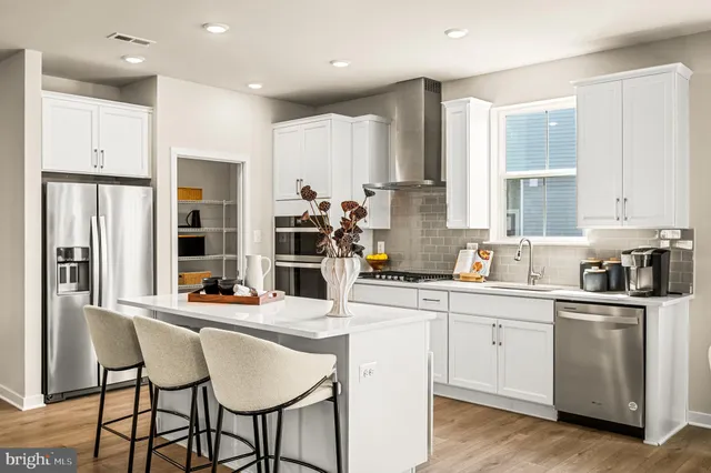 a kitchen with stainless steel appliances kitchen island granite countertop a sink and cabinets