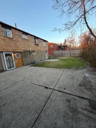 a backyard of a brick building with large trees