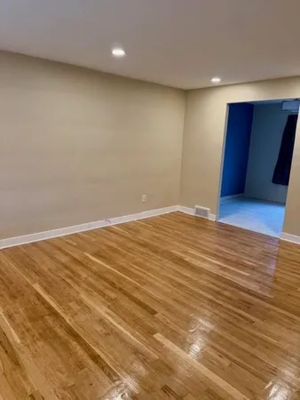 a view of an empty room with wooden floor
