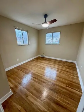 a view of an empty room with a chandelier fan