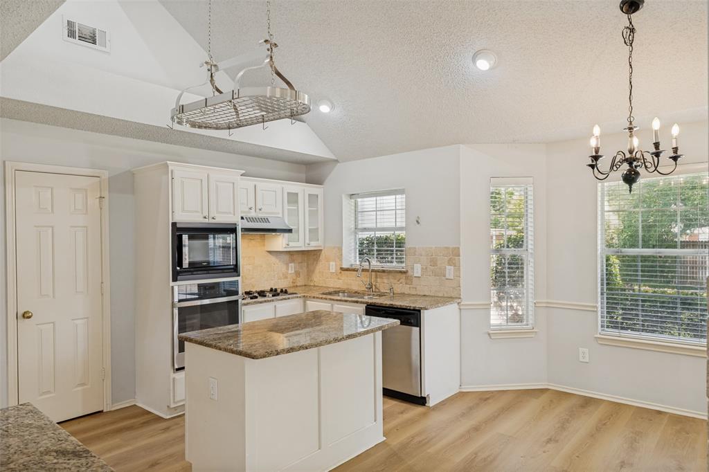 1215 Spring Creek Drive Allen, TX 75002 - Photo 9 of 40 Kitchen featuring a vaulted ceiling with pot rack, recessed lighting, and wood-finish flooring