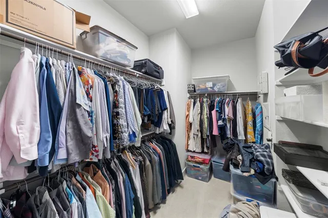 a view of walk in closet with clothes