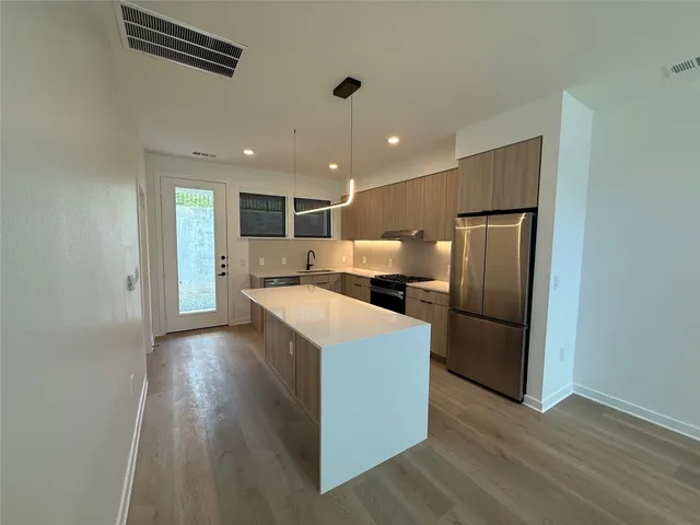 a view of kitchen with refrigerator microwave and wooden floor