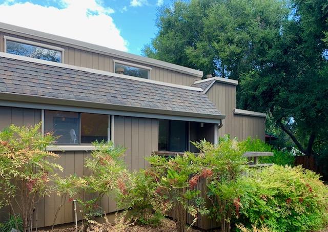 a front view of a house with plants and garden