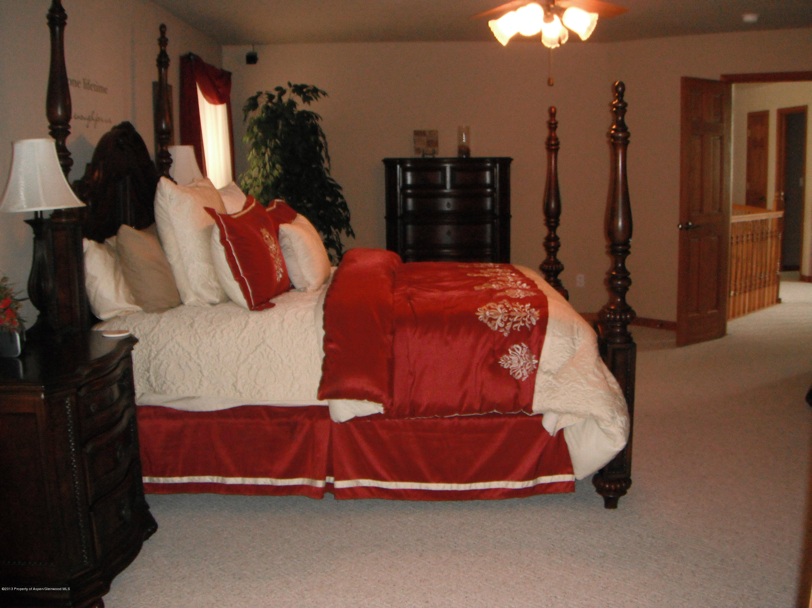 1298 Fir Avenue Rifle, CO 81650 - Photo 13 of 27 a bedroom with a bed and a chandelier
