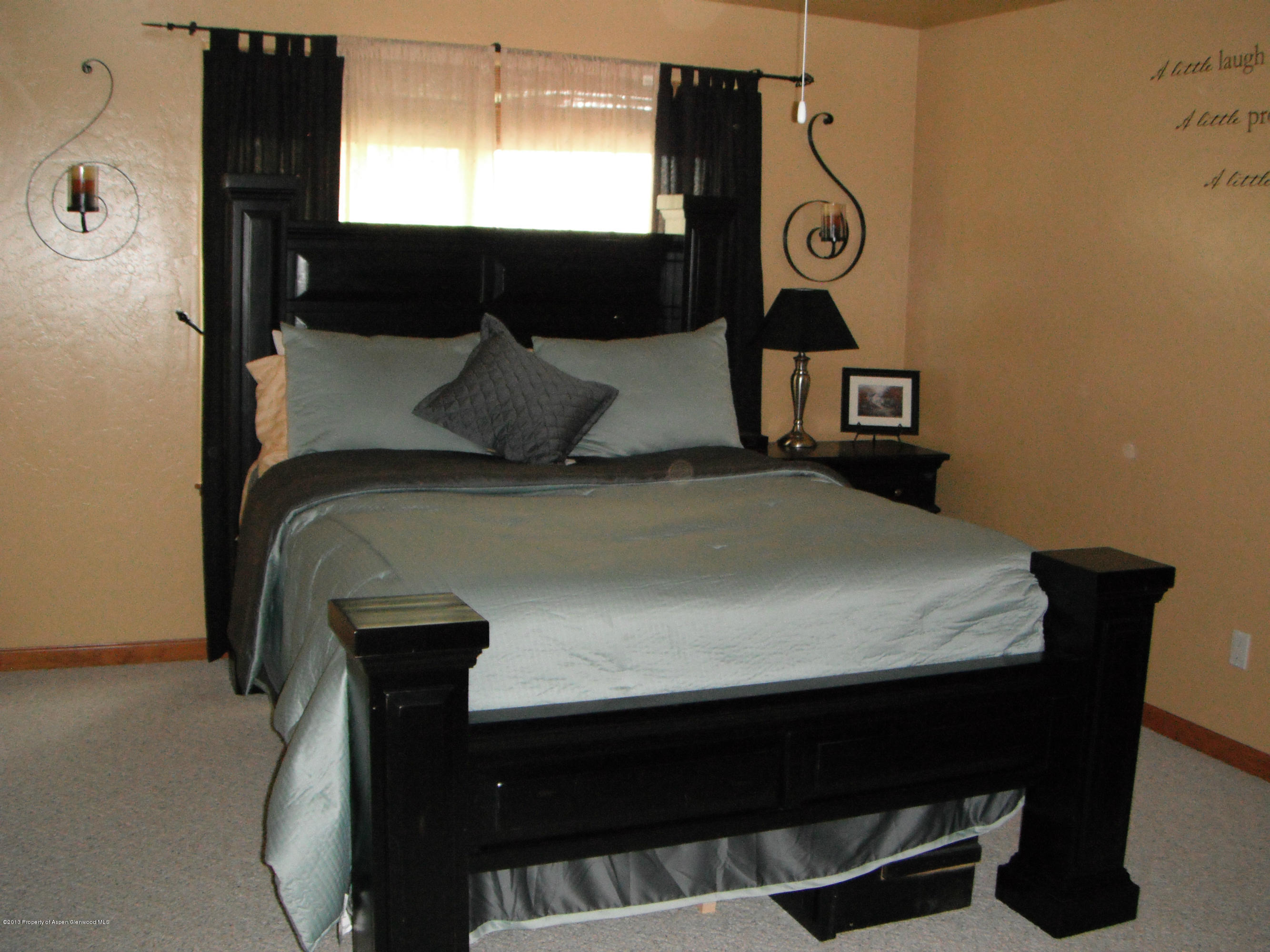 1298 Fir Avenue Rifle, CO 81650 - Photo 17 of 27 a bed sitting in a bedroom next to a window