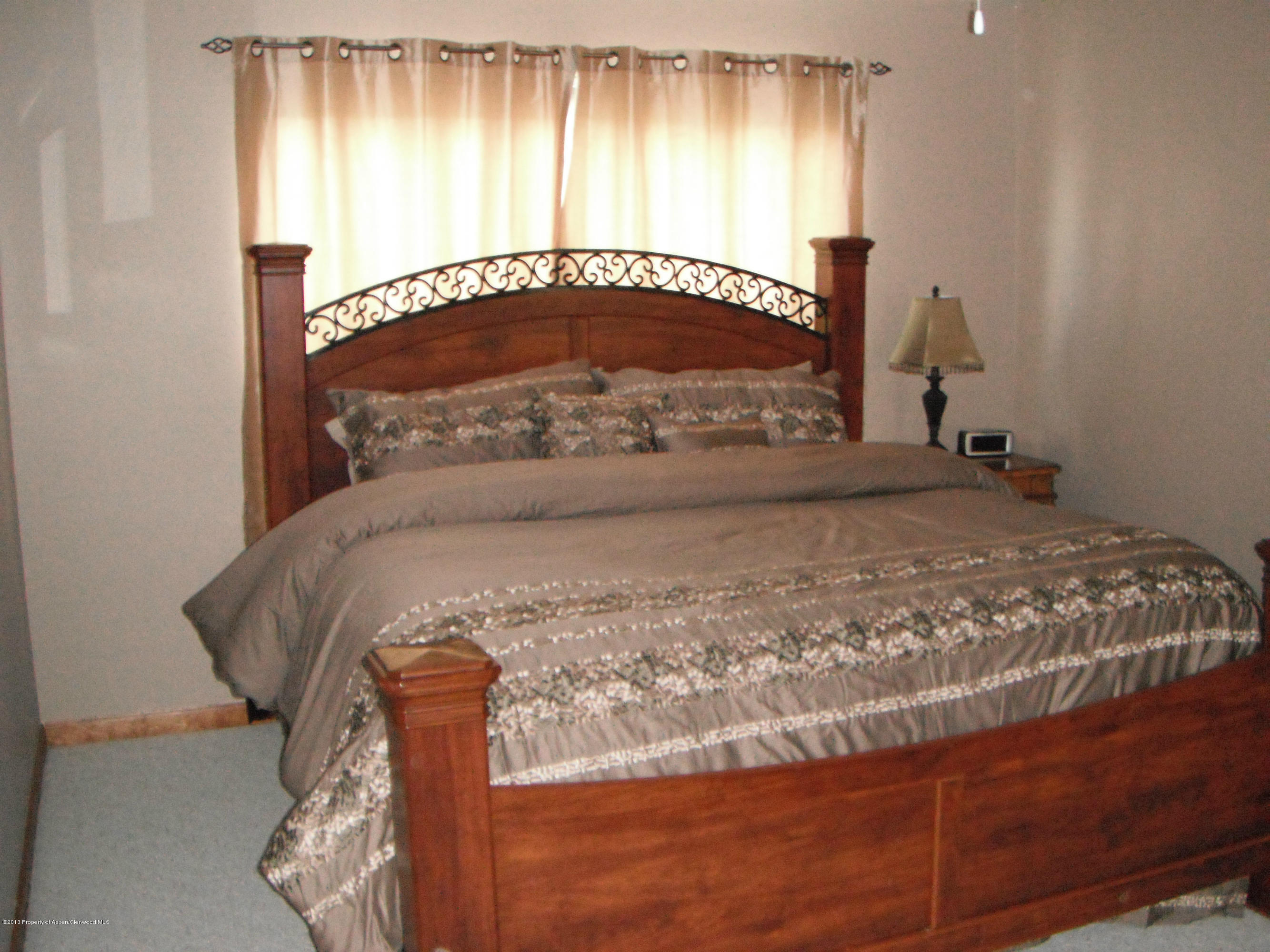 1298 Fir Avenue Rifle, CO 81650 - Photo 18 of 27 a bed sitting in a bedroom next to a window