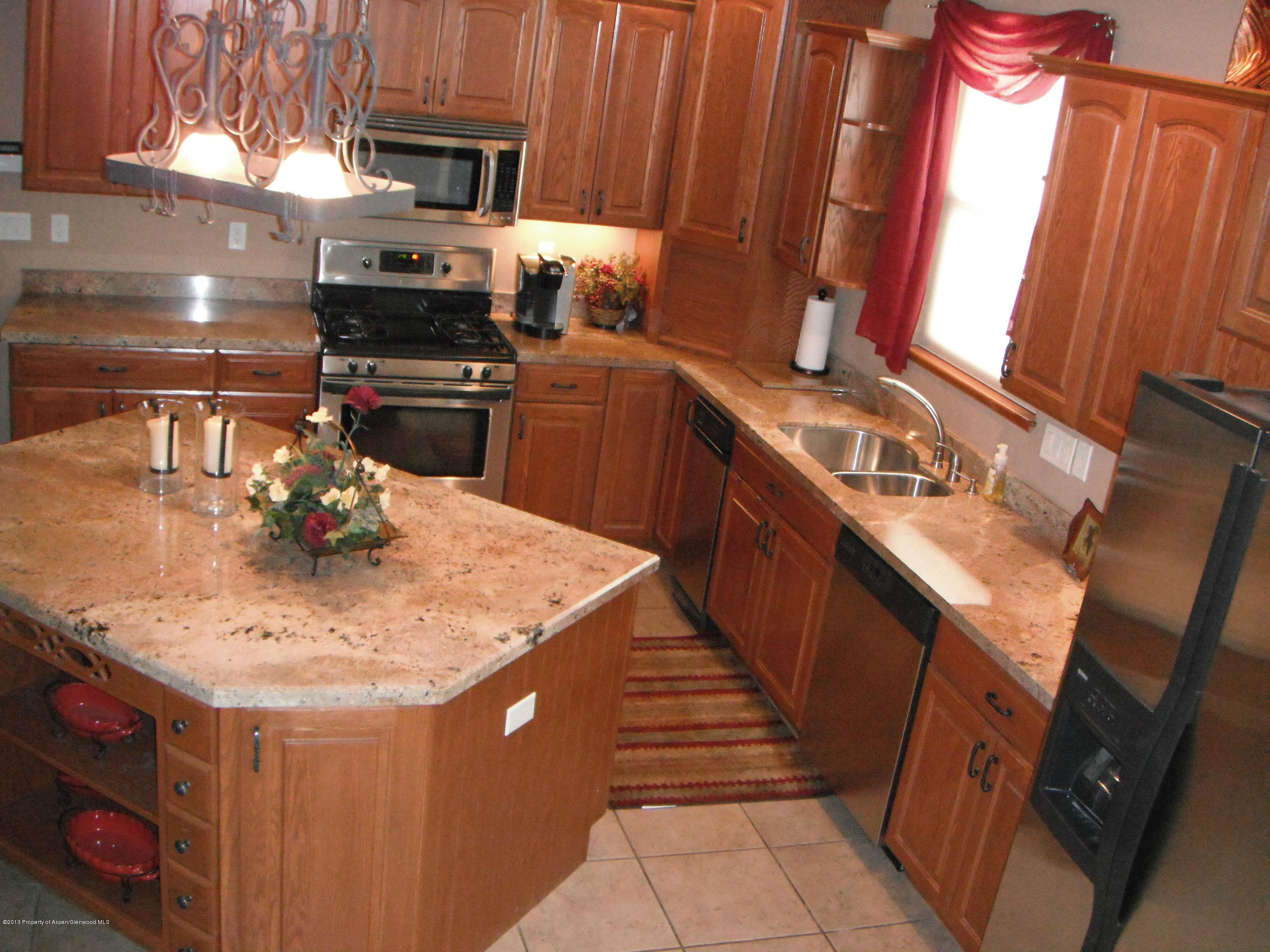 1298 Fir Avenue Rifle, CO 81650 - Photo 10 of 27 a kitchen with stainless steel appliances wooden cabinets granite counter tops and a stove