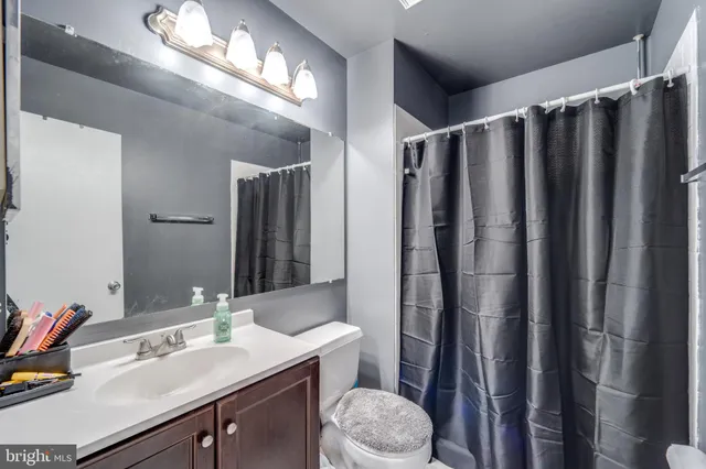 a bathroom with a sink a toilet a mirror and shower