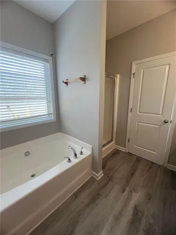 a bathroom with a tub a sink and a window