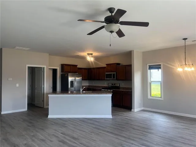 a view of a kitchen with a sink wooden floor and a window