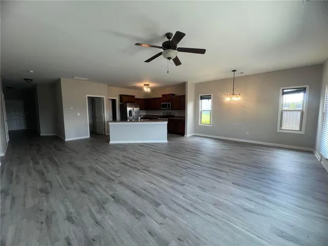 a view of a big room with wooden floor and windows