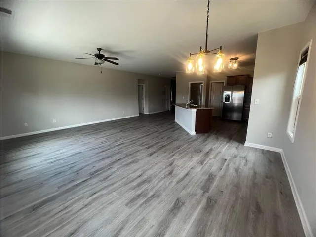 a view of a room with wooden floor and kitchen view