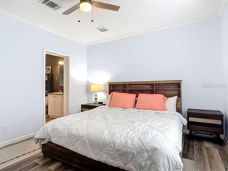 102 Ash Street Edgewater, FL 32141 - Photo 18 of 36 a bedroom with a bed and a chandelier