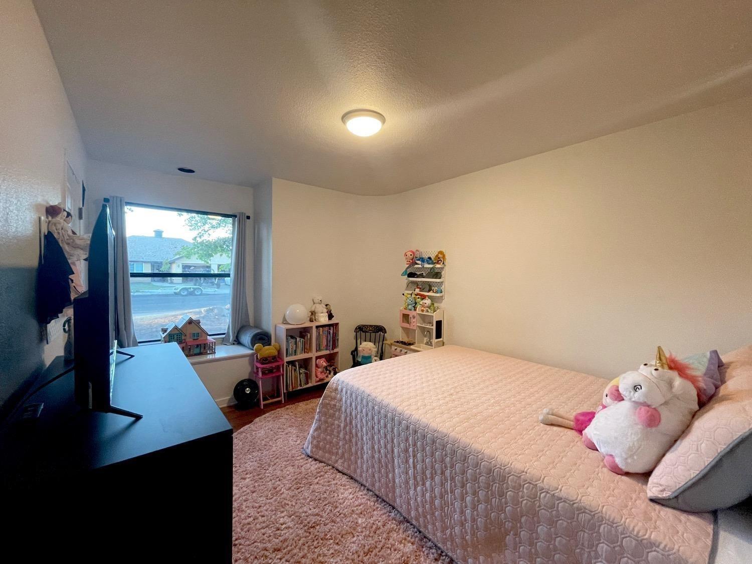 1956 Richert Avenue Clovis, CA 93611 - Photo 9 of 18 a bedroom with a bed and large windows