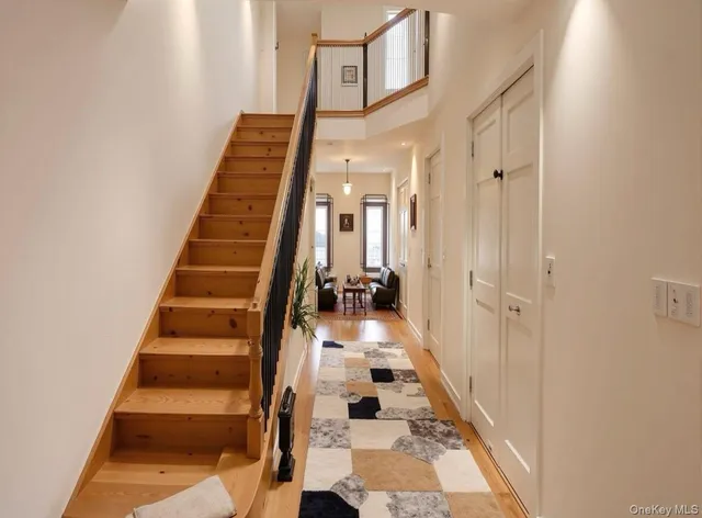 a view of a hallway with front door wooden floor and stairs
