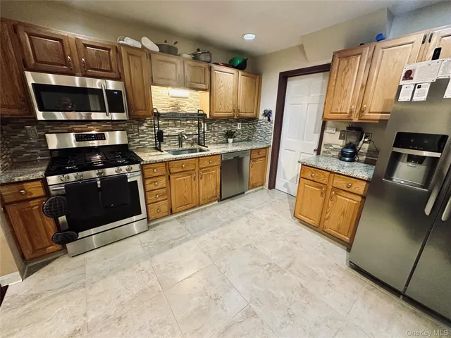 a kitchen with stainless steel appliances granite countertop a stove a sink and a microwave