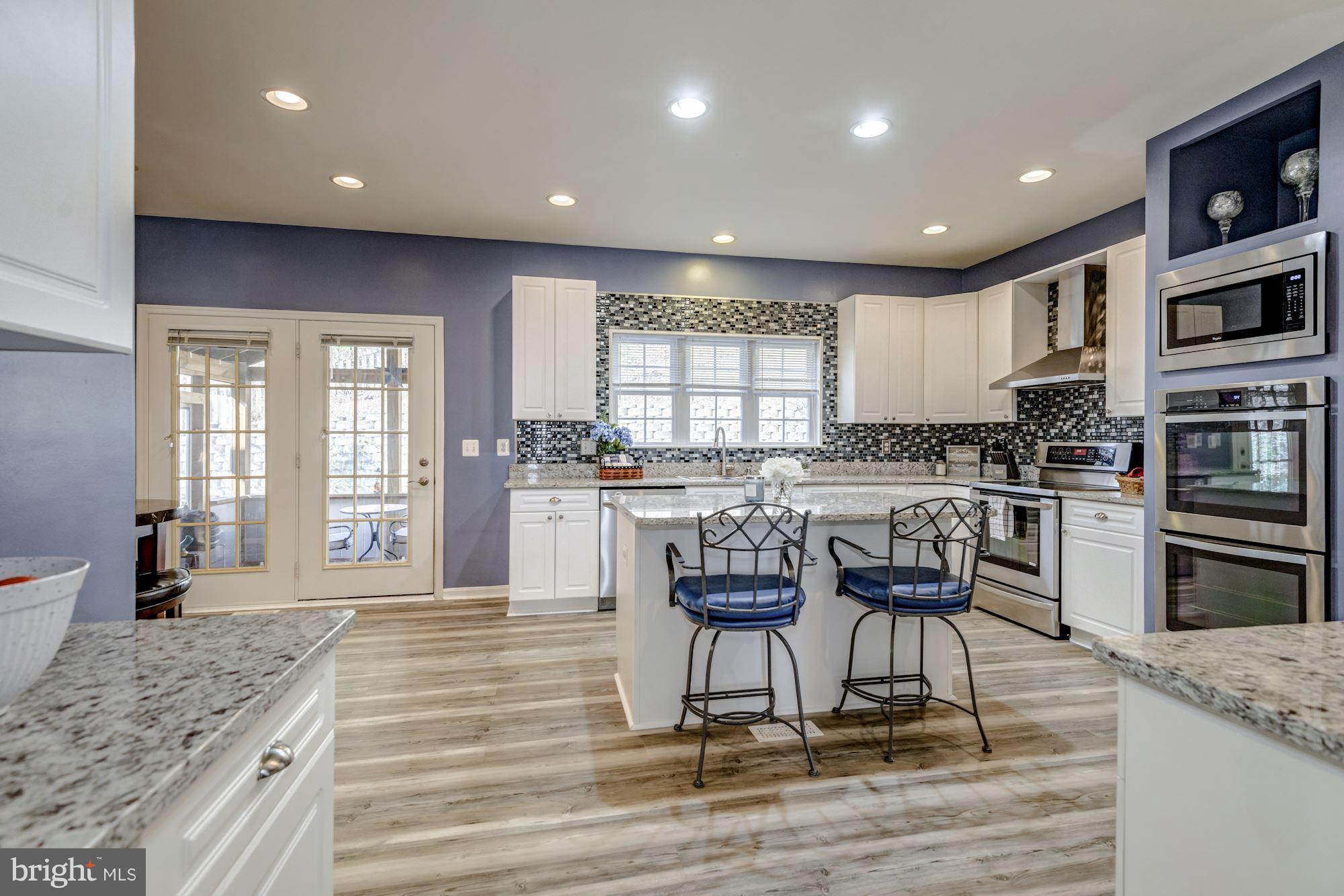 6092 Deer Ridge Trail Springfield, VA 22150 - Photo 5 of 30 a kitchen with granite countertop a stove and cabinets