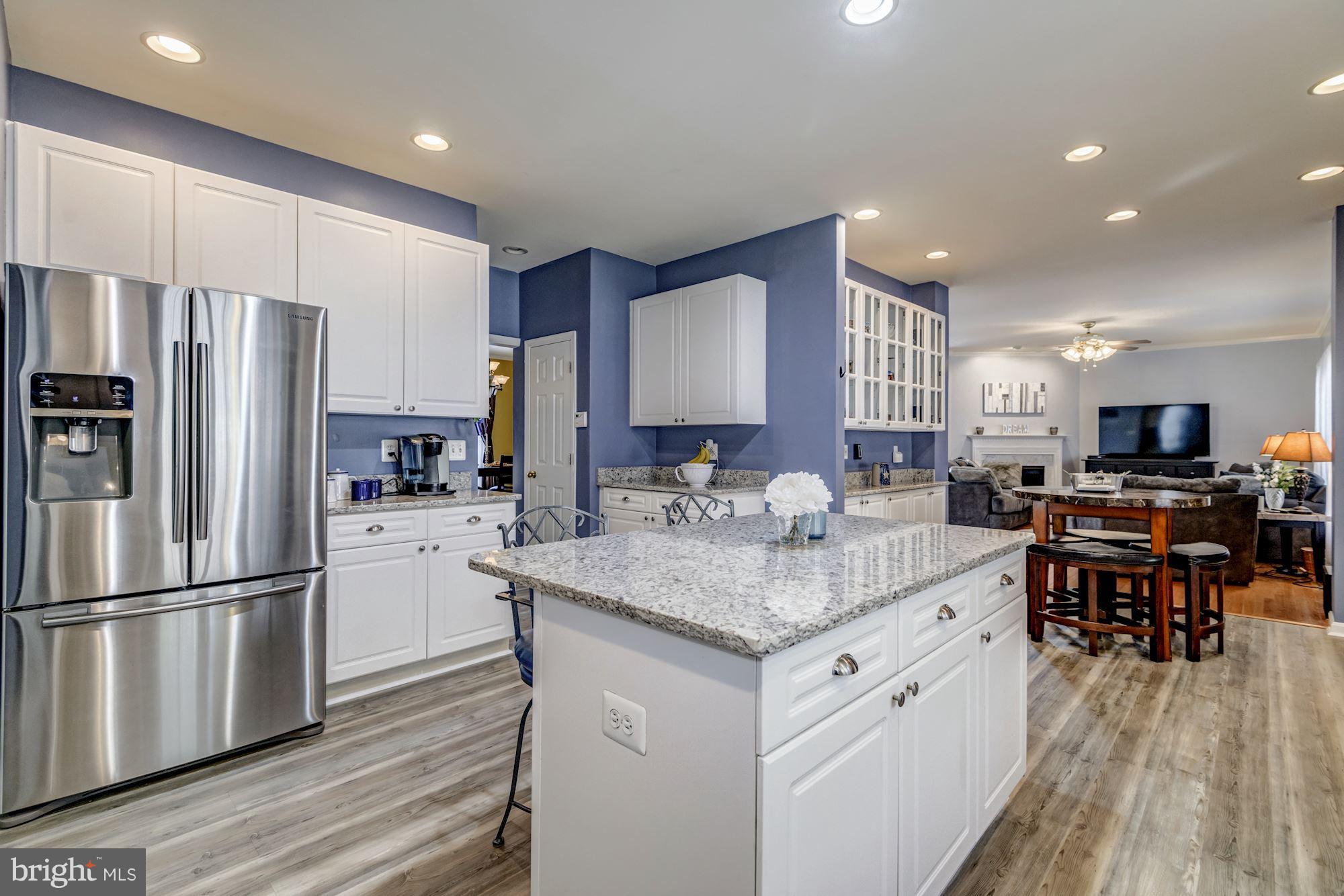 6092 Deer Ridge Trail Springfield, VA 22150 - Photo 8 of 30 a kitchen with stainless steel appliances granite countertop a refrigerator a stove a sink dishwasher and a refrigerator with wooden floor