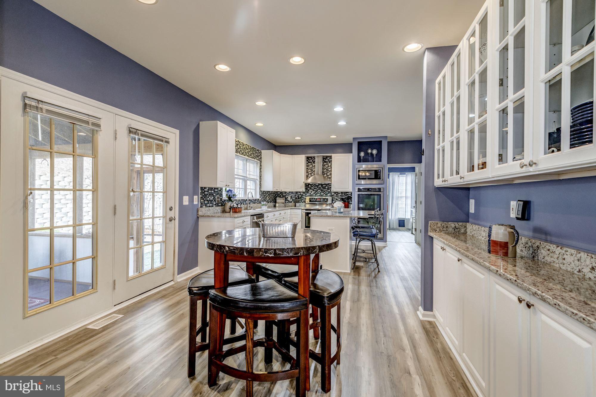 6092 Deer Ridge Trail Springfield, VA 22150 - Photo 9 of 30 a kitchen with a table chairs stove and cabinets