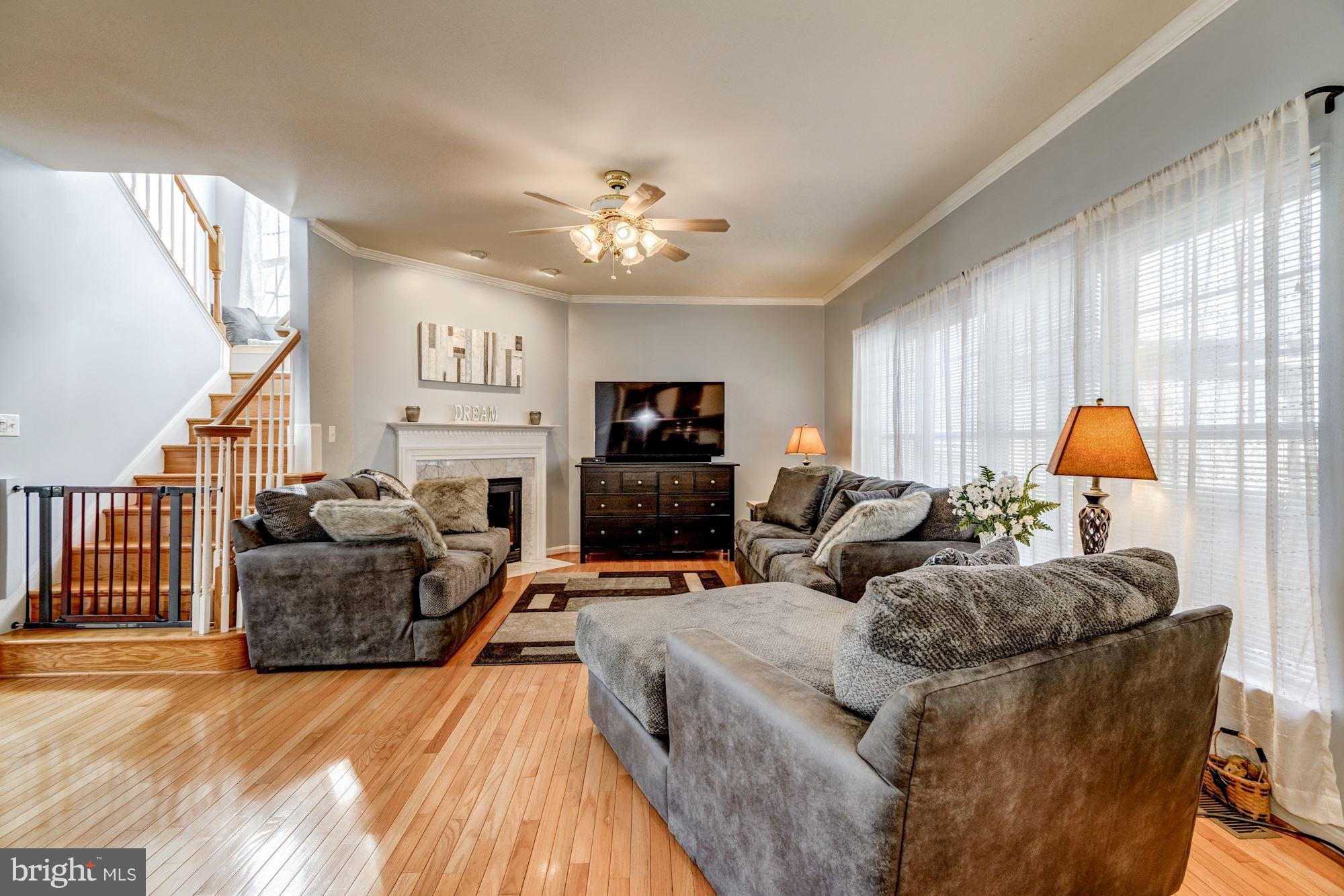 6092 Deer Ridge Trail Springfield, VA 22150 - Photo 10 of 30 a living room with furniture a fireplace and a flat screen tv