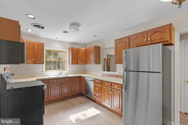 a kitchen with a sink a refrigerator and cabinets