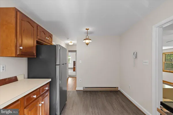 a kitchen with a refrigerator a sink and wooden floor