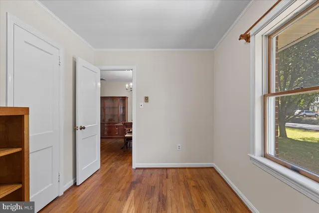 a view of a hallway view with wooden floor and dining room