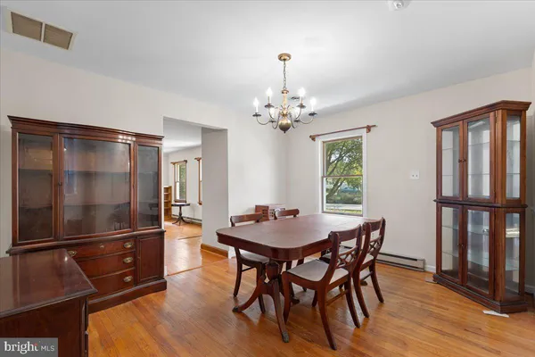 a dining room with furniture a chandelier and wooden floor
