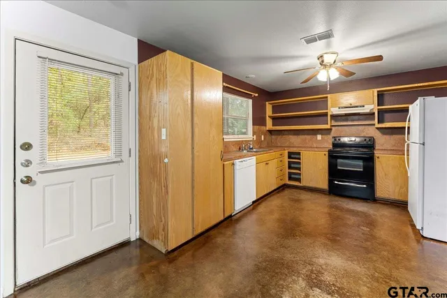 a view of a kitchen with furniture and a ceiling fan