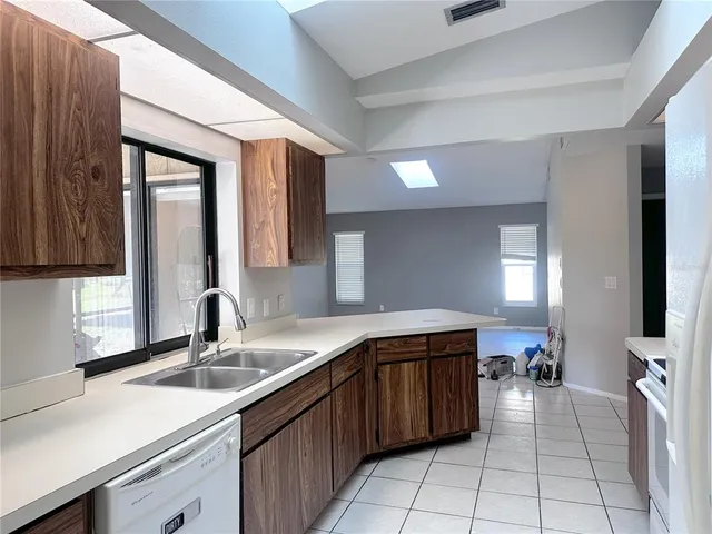 a view of a big room with windows and chandelier fan
