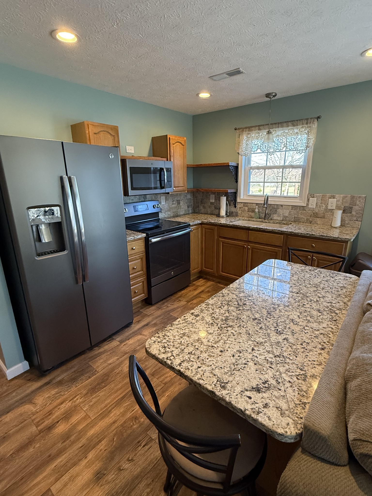 334 North Centerpoint Road Portland, TN 37148 - Photo 32 of 43 a kitchen with stainless steel appliances granite countertop a refrigerator oven a sink dishwasher and wooden cabinets with wooden floor