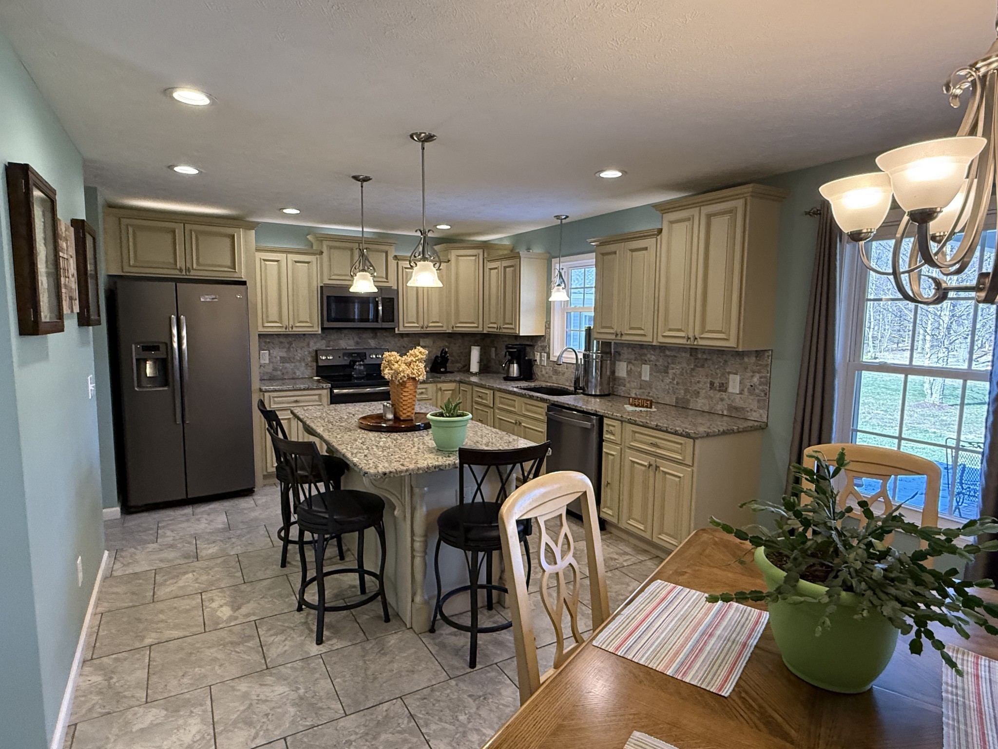 334 North Centerpoint Road Portland, TN 37148 - Photo 7 of 43 a kitchen with stainless steel appliances kitchen island granite countertop a refrigerator a sink a stove a dining table and chairs with wooden floor