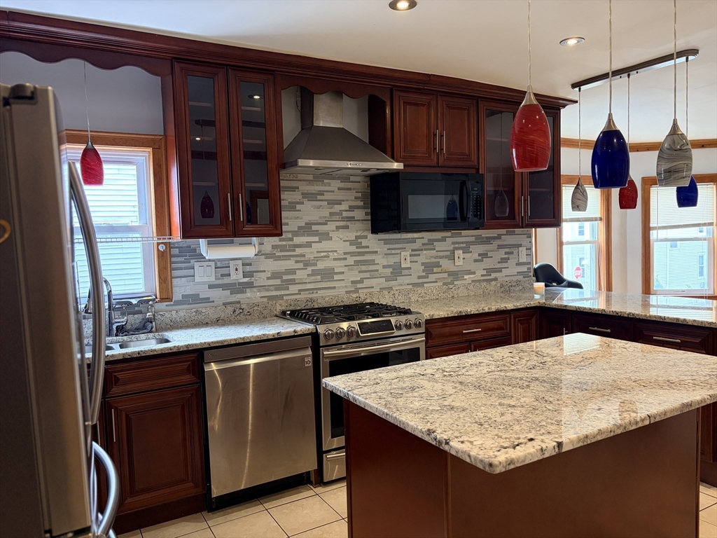 91 Ward Street, Unit 1 Worcester, MA 01610 - Photo 3 of 12 a kitchen with stainless steel appliances granite countertop a sink and cabinets