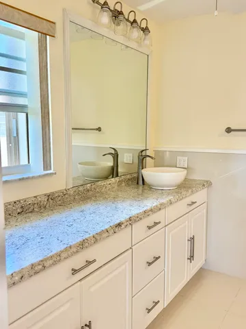 a bathroom with a granite countertop sink and a mirror